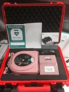 Red case with defibrillator and posters inside