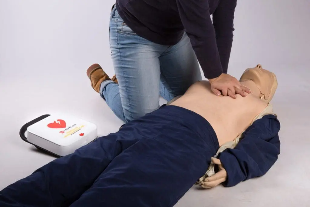 Man administering CPR to a dummy with the Lifepak CR2 Defibrillator